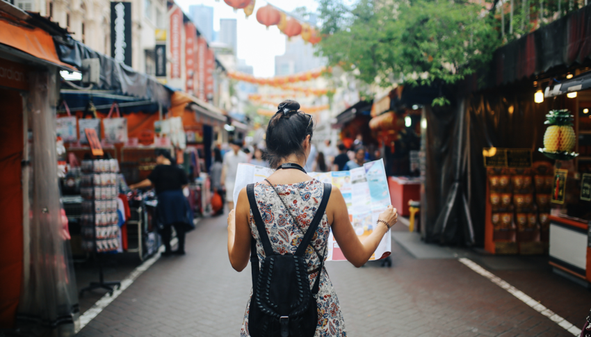 Woman looking at map while standing in center of street