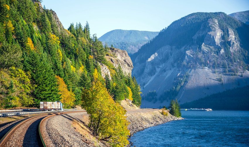 Winding road and railroad tracks along the water through the Columbia River Gorge