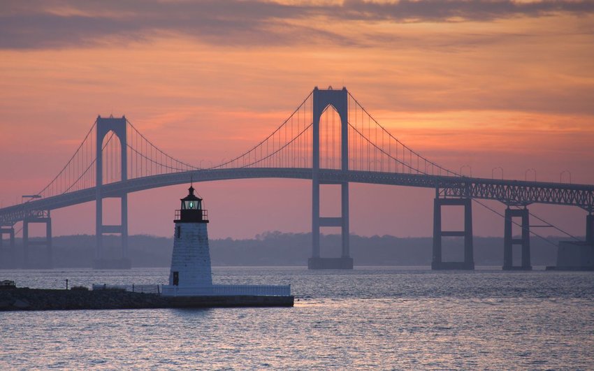 Goat Island Lighthouse with Newport Bridge in background at sunset