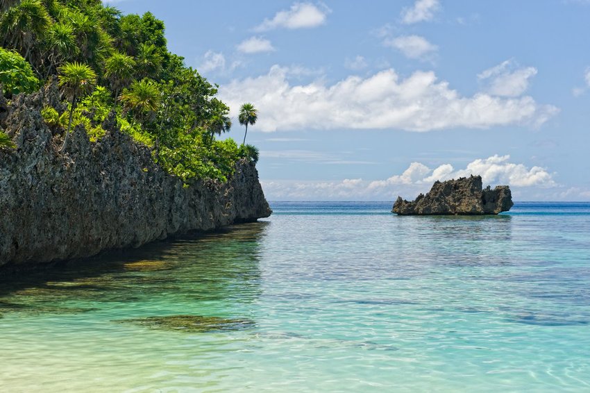 Beach and crystal clear water with cliffside in West Bay, Roatan