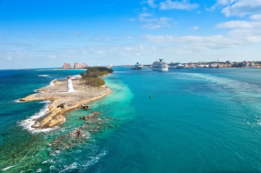 Cruise ships sailing in Nassau, Bahamas with lighthouse on island