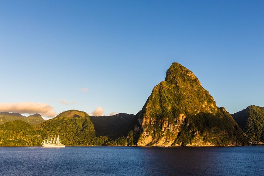 Coast of the island of St. Lucia with a boat with sails in the water