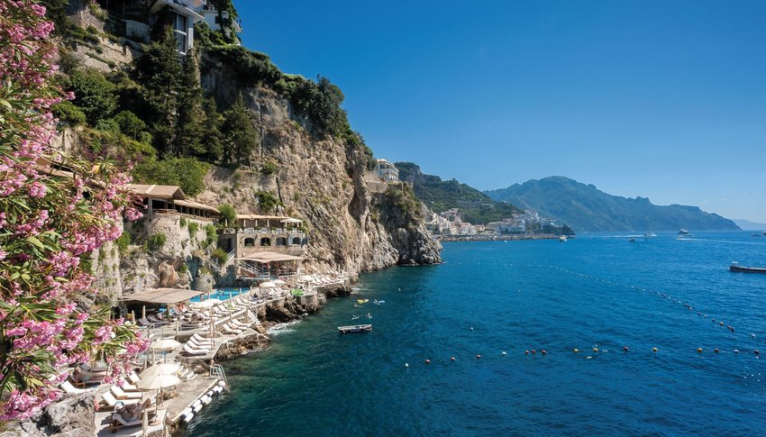 View of Hotel Santa Caterina at bottom of cliff next to the ocean