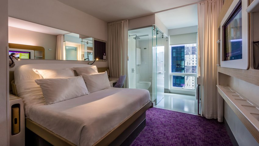 Interior of a bedroom with a raised bed and a TV