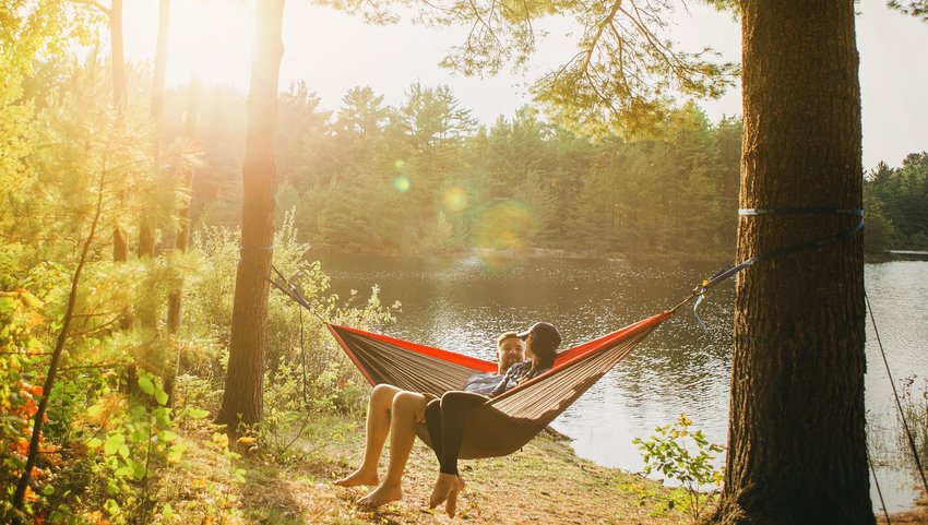 Two people relaxing and talking in a hammock