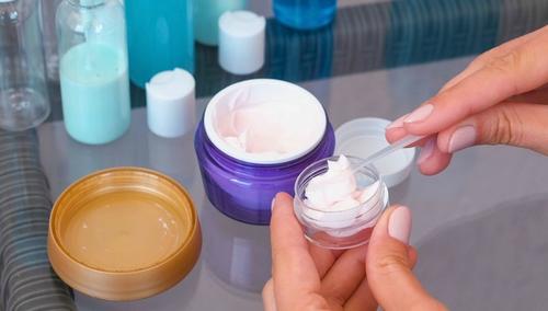 Person putting lotion in travel sized container