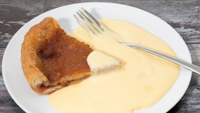 Bakewell pudding on white plate with custard