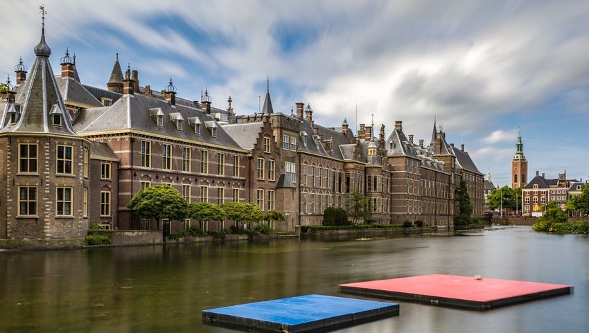 Exterior view of Het Binnenhof with water in front on cloudy day