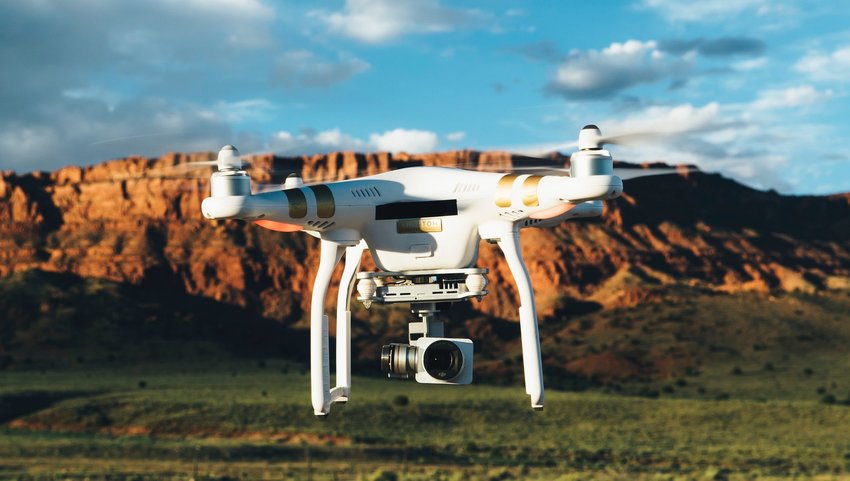 Drone with camera flying with rock formation in background