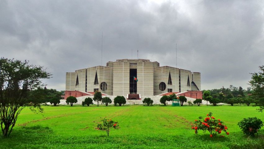 National Parliament House on cloudy day with green grass in front