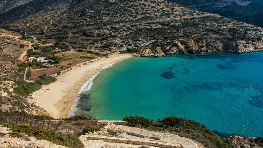 Hidden beach from above with stone pathway down to the water