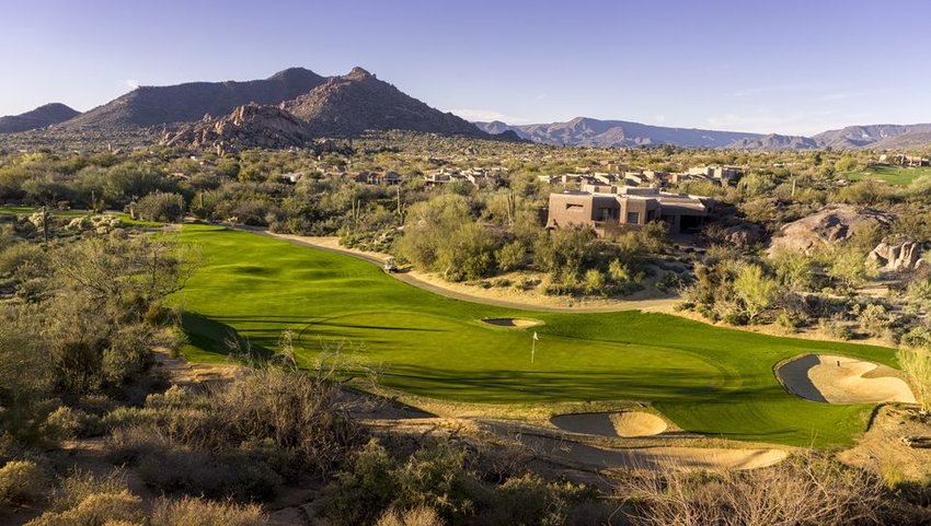 Overhead view of golf course with mountains in distance 