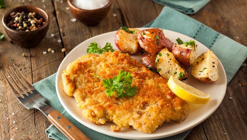 Wiener Schnitzel on white plate with potatoes