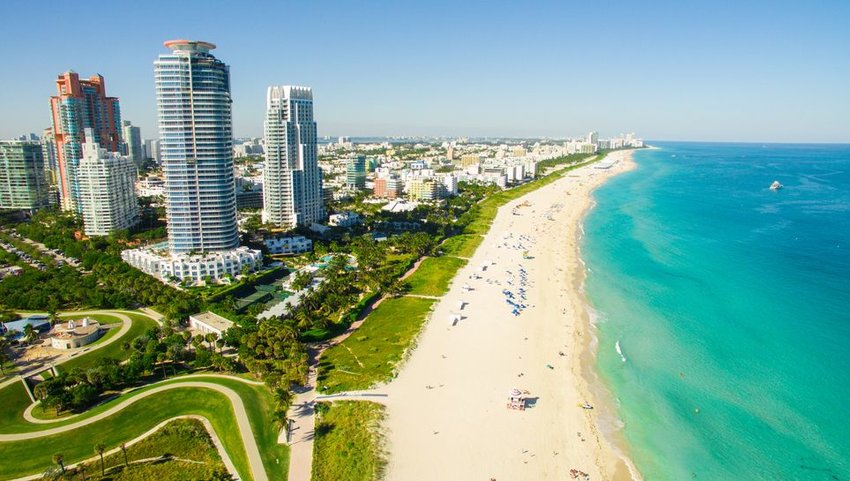 Aerial view of South Beach with blue waters on the right and buildings on the left