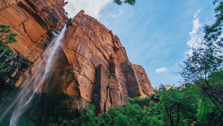 Waterfall coming down from huge red rock face 