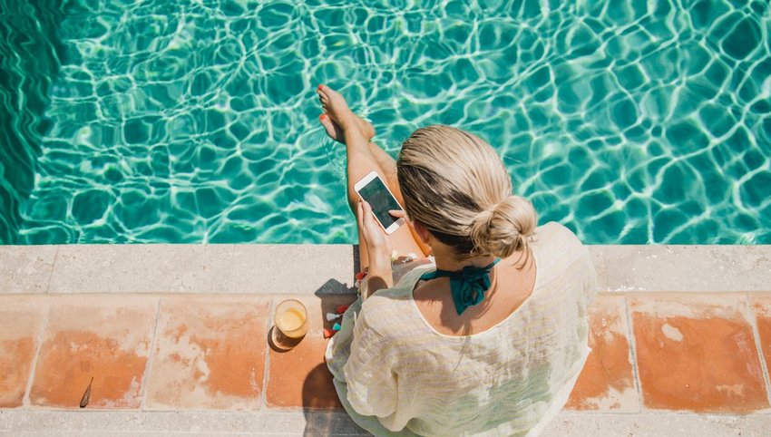 Person sitting on edge of pool with feet in water