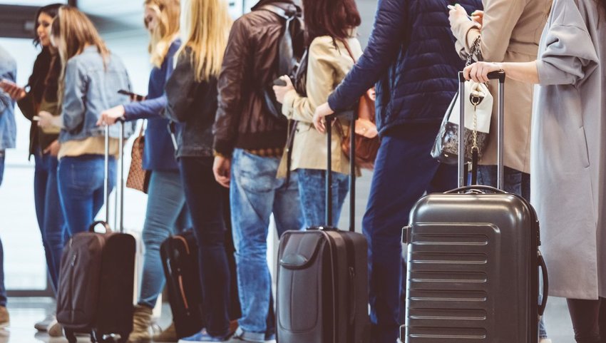 People waiting in line with their luggage