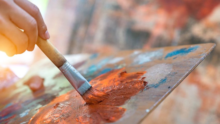 Person painting with orange paint