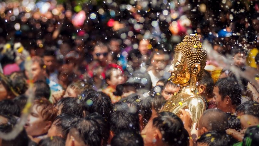 Crowd of people lifting up a Buddha statue