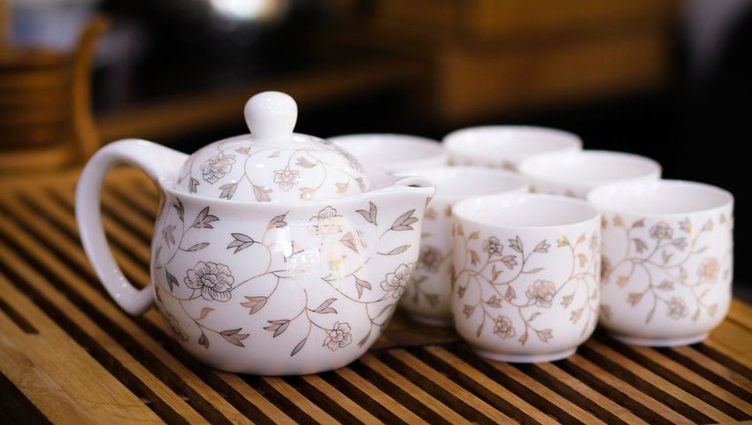 Teapot and cups on wooden tray 