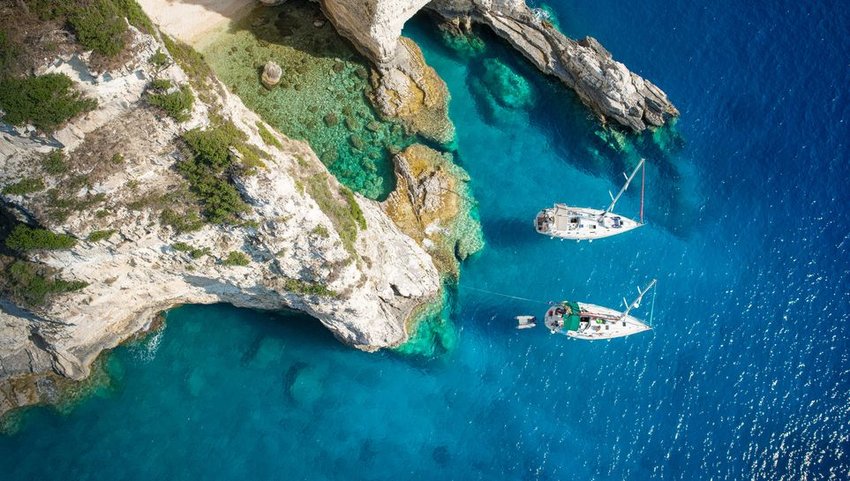 Sailboats next to cliffs in Greece