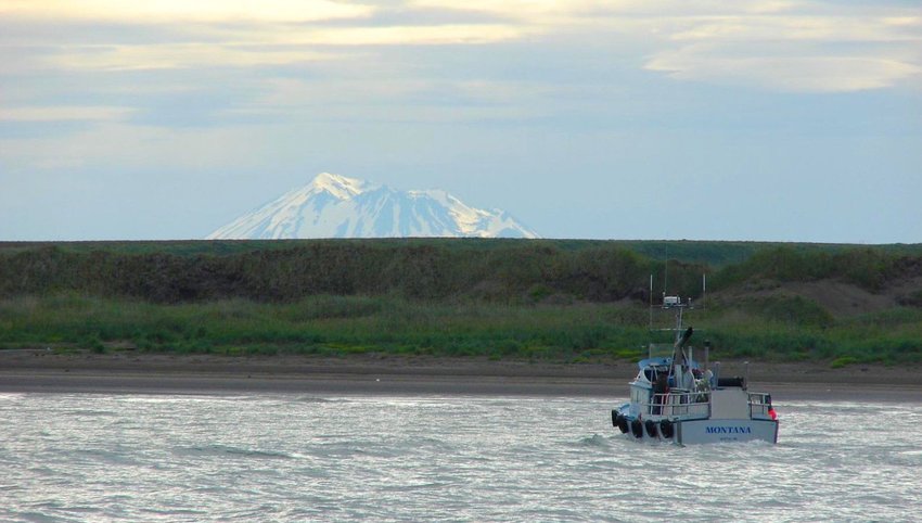 Boat in water with mountain peak in distance 