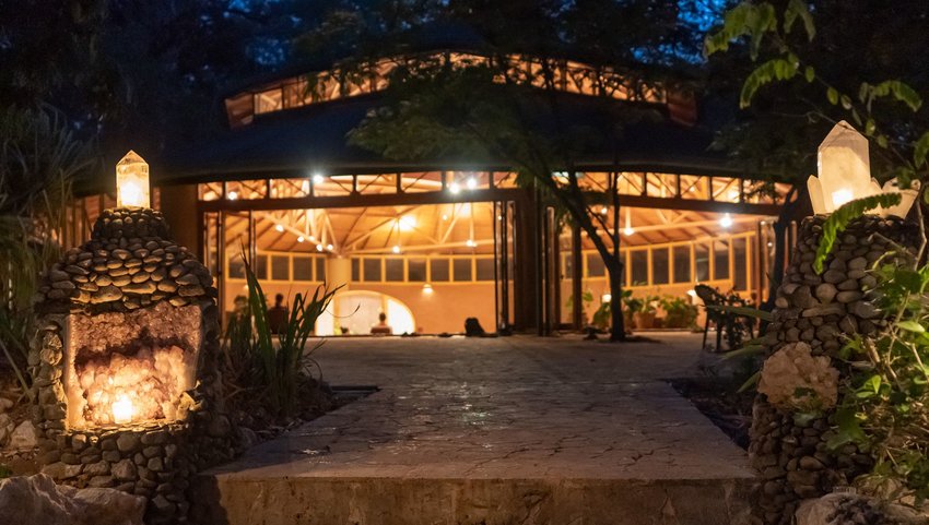 Exterior of meditation hall at night with lights on