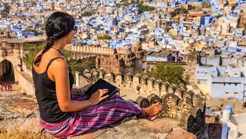 Barefoot traveler looking out over city