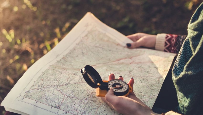 Person holding compass and map