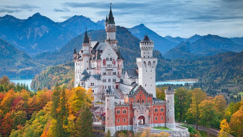 Neuschwanstein Castle on an autumn day with mountains and lake in background