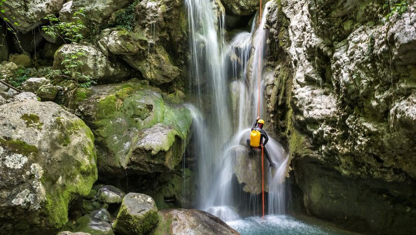 Person canyoneering down a waterfall