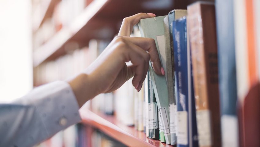 Person pulling book off shelf