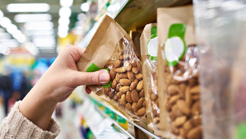 Person grabbing bag of almonds off shelf 