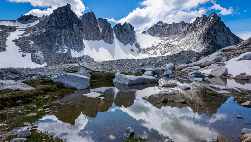 Mountain lake reflection with blue sky and clouds in Enchantments in Washington State