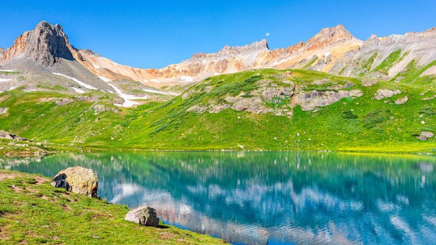 Ice Lakes Basin trail with blue lake in front of mountains 