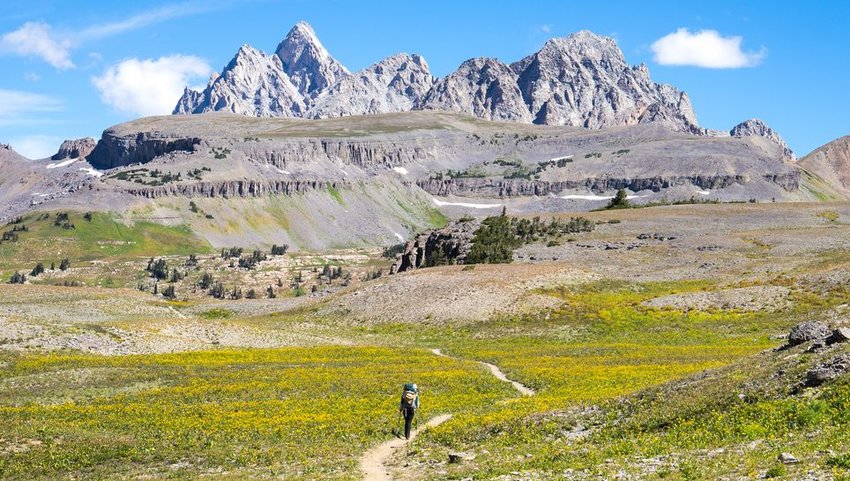 Person hiking down the Teton Crest trail with backpack on