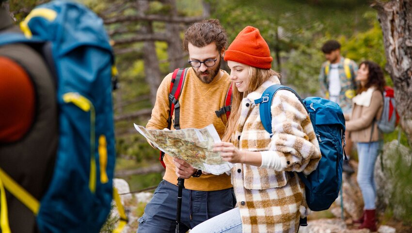 A man and woman studying a map while hiking.