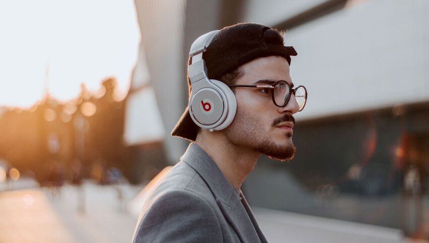 A young man wears silver headphones.