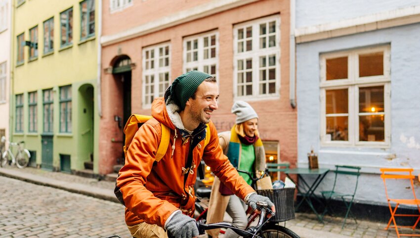 A man on a bike smiling.