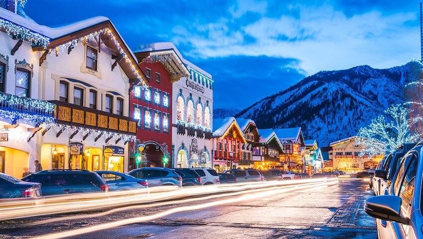 Shops with Christmas lights with mountains in the background.