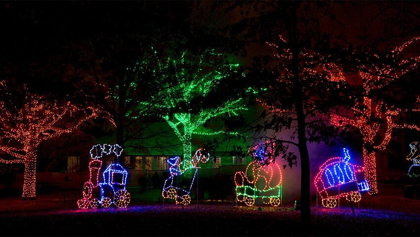 Trees with lights and light display of a train at the Smithsonian’s National Zoo.