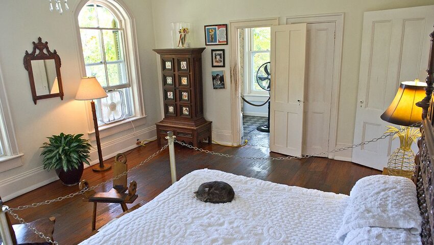Bedroom in the home and museum of Ernest Hemingway with a cat sleeping on the bed. 