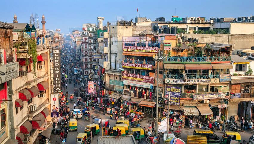 Crowded street in New Delhi, full of hotels, lodges, and restaurants.