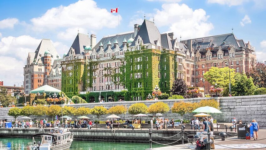 People walking along Inner Harbour of Victoria, Vancouver Island, B.C., Canada.