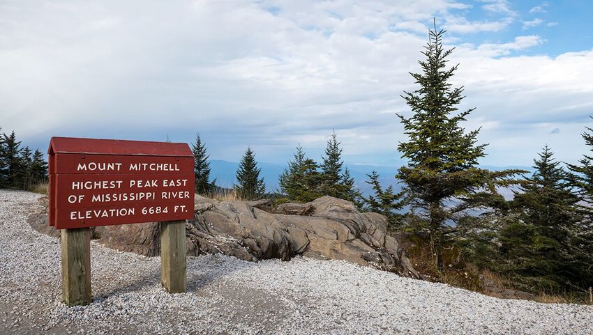 Sign at the summit of Mount Mitchell stating it's the highest peak eat of Mississippi River.