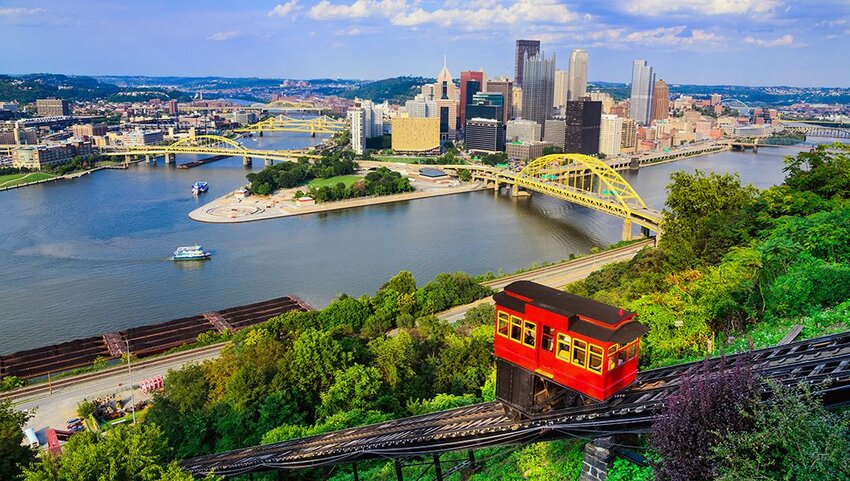 Cable car with Pittsburgh skyline behind it. 