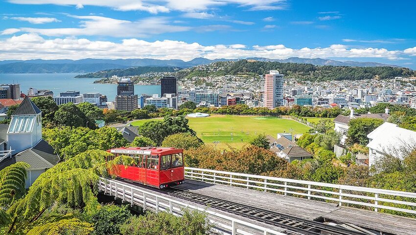 Wellington Cable Car with ocean and city behind it.