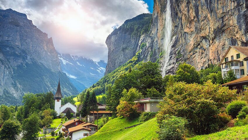 Village and church in front of Staubbach waterfall in Lauterbrunnen, Switzerland.