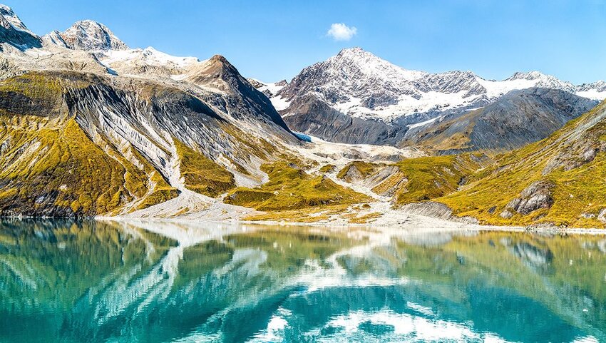 Glacial landscape showing mountain peaks and glaciers on clear blue sky summer day.