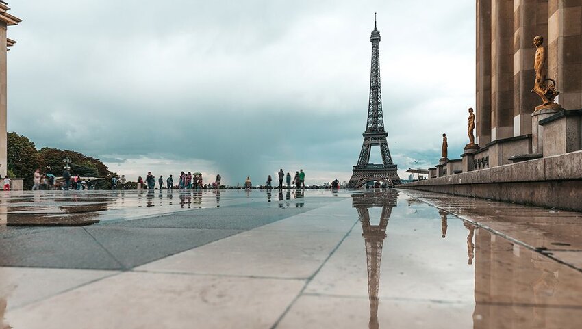 View of the Eiffel Tower in a rainy day with reflections on the Trocadero floor.